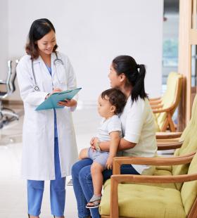 Asian female doctor consults with mother and baby