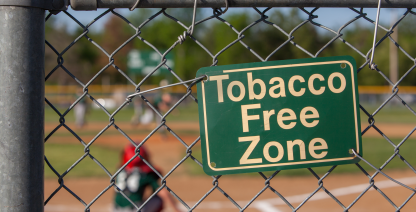 Tobacco Free Zone sign hangs at a baseball game.