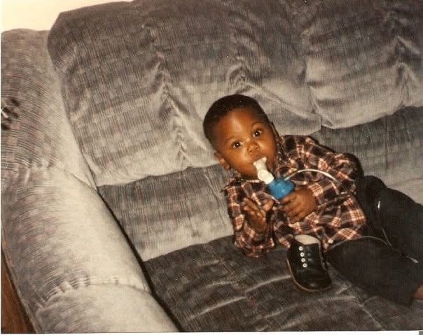 Andre as a child sitting on a couch