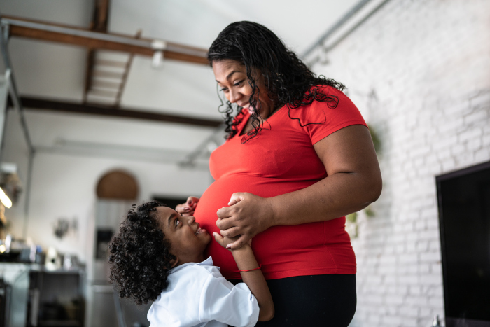 Madre embarazada y niña sonriendo