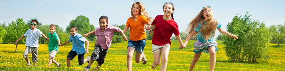 children running in a field holding hands