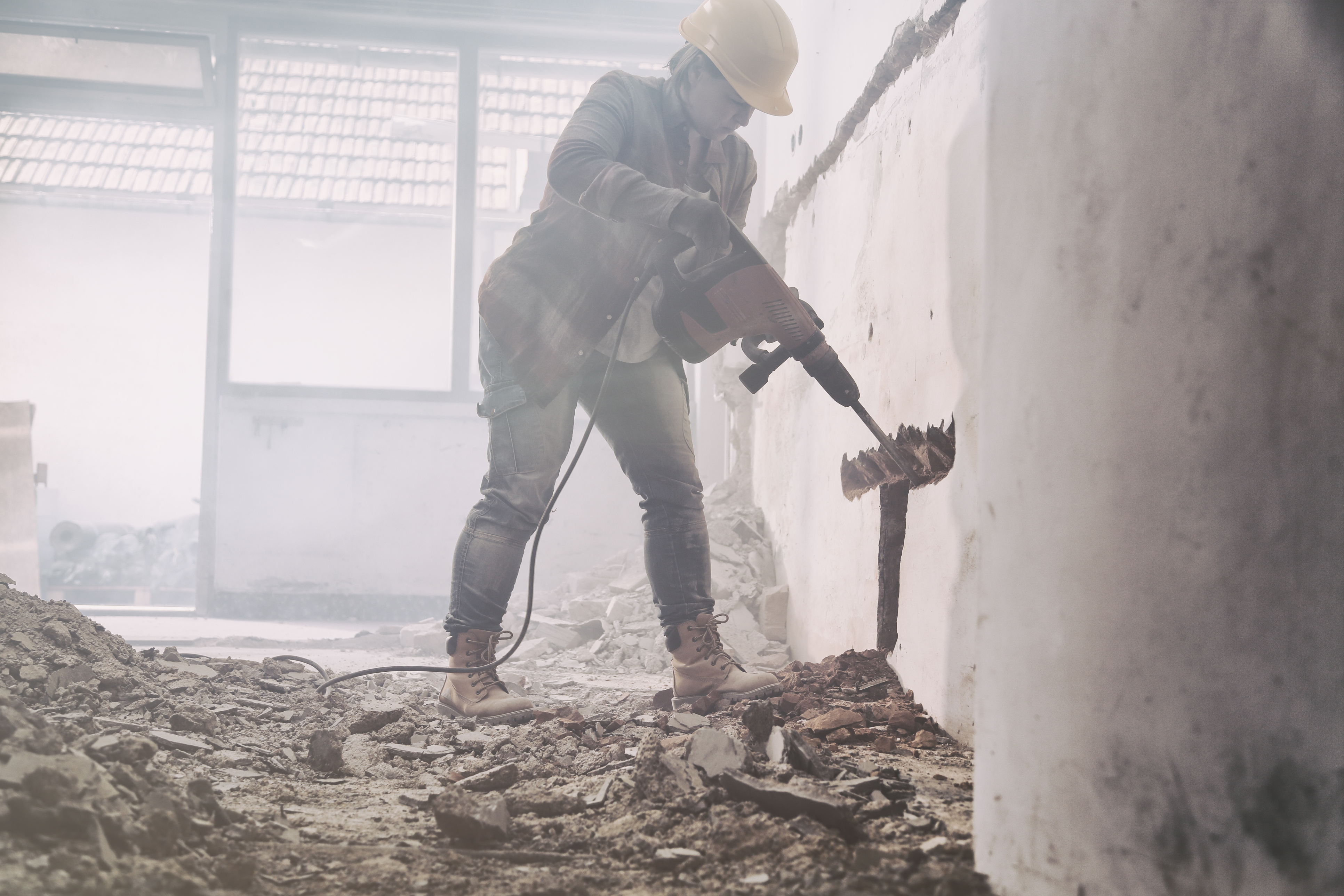 Construction worker drilling into concrete.