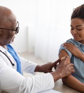 Doctor putting bandage on woman