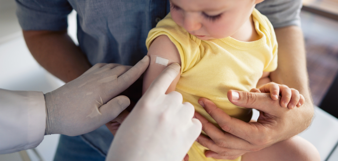 A child gets a Band-Aid after a vaccine.