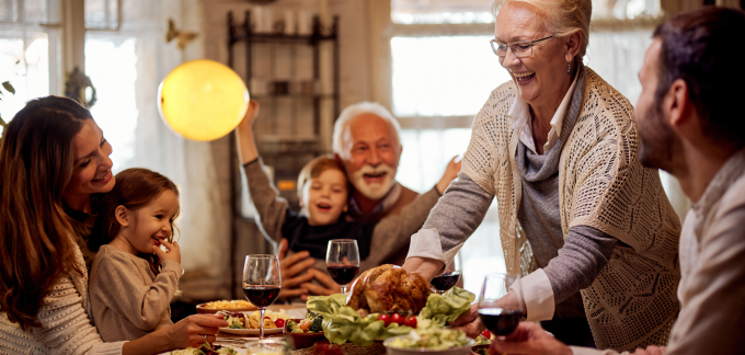 A family gathers around the table for Thanksgiving dinner.