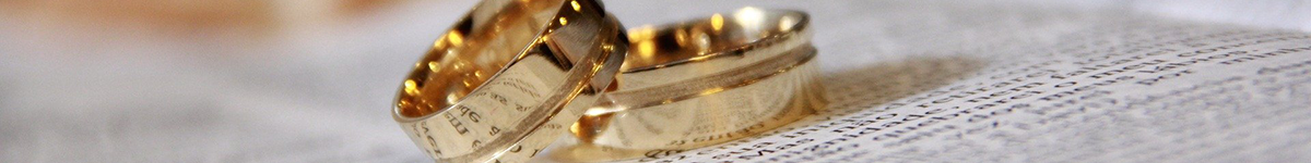 A pair of wedding bands lie on an open book